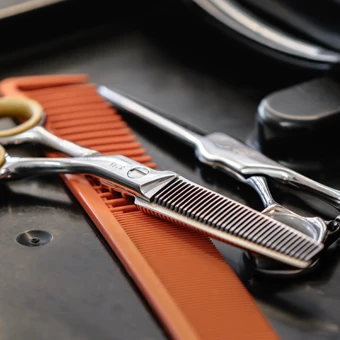 Friseurwerkzeuge mit Schere und Kamm am Arbeitsplatz