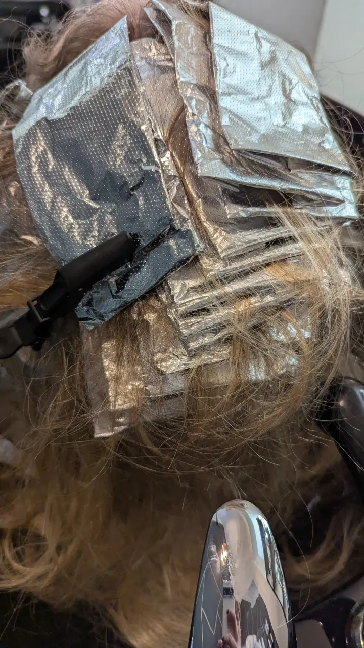 Aluminiumfolien waehrend einer Coloration im Salon