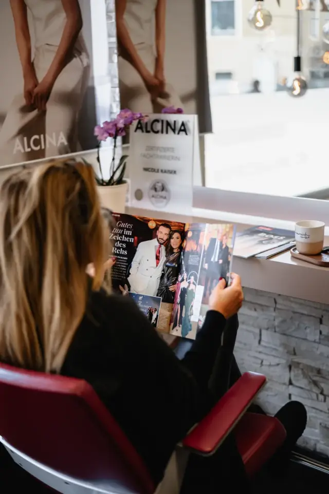 Kundin liest eine Zeitschrift im Wartebereich des Salons bei Kaiserreich Hairstyle in Nürnberg