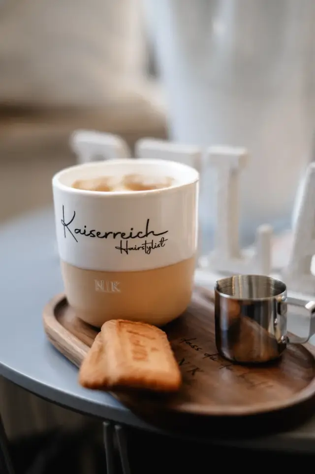 Kaffeebecher und Croissant auf einem Serviertablett bei Kaiserreich Hairstyle in Nürnberg