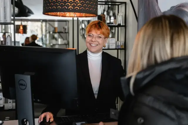 Stylistin an der Rezeption im Gespräch mit einer Kundin bei Kaiserreich Hairstyle in Nürnberg