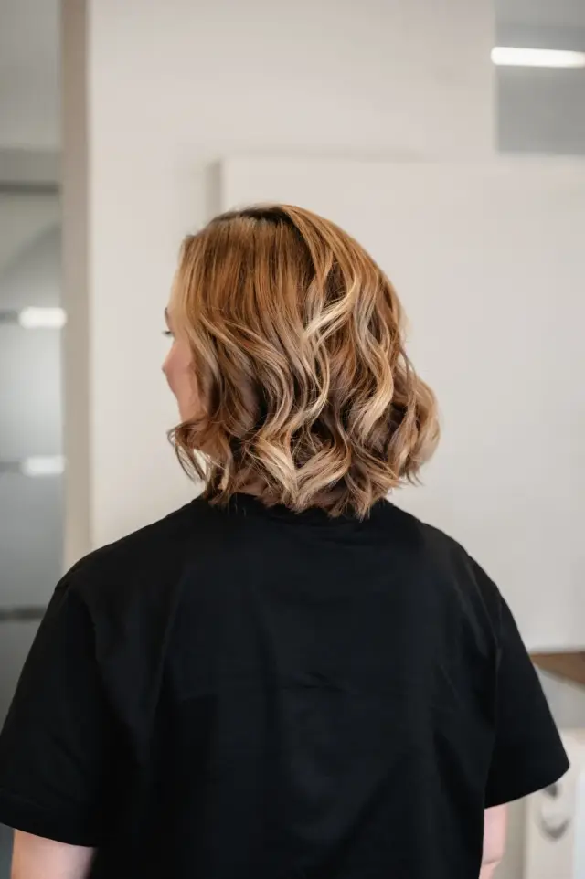 Seitliche Ansicht einer lockigen brünetten Frisur bei Kaiserreich Hairstyle in Nürnberg