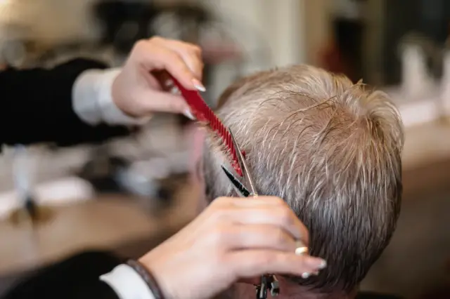 Kamm und Schere beim Schneiden von kurzem grauem Haar bei Kaiserreich Hairstyle in Nürnberg