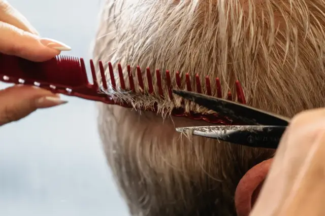 Detailaufnahme eines Herrenhaarschnitts mit Kamm und Schere bei Kaiserreich Hairstyle in Nürnberg