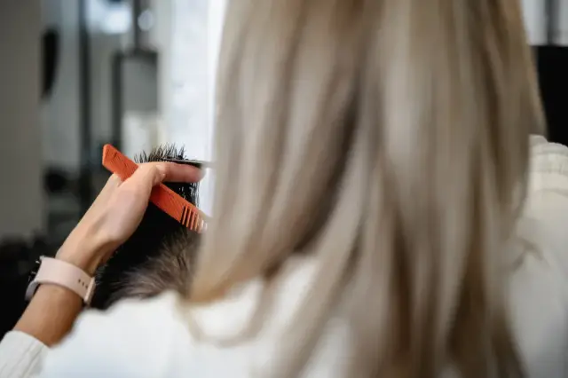Blonde Stylistin schneidet das Haar eines männlichen Kunden bei Kaiserreich Hairstyle in Nürnberg